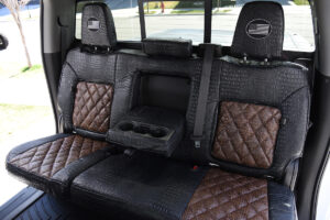 2024 GMC Sierra 3500 rear armrest with cup holders in Java Croc Diamond Stitch and Midnight Croc seat covers