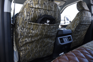 Rear pocket view of 2026 Ford F-350 seat covers in Brown Ostrich Diamond Stitch leatherette and Mossy Oak Bottomland camouflage